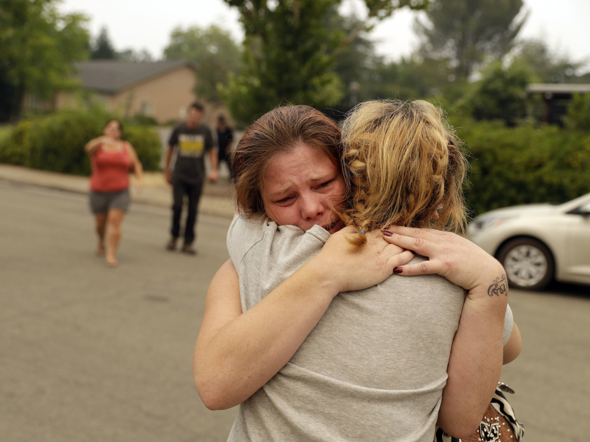 Carla Bledsoe, facing camera, hugs her sister Sherry outside of the sheriff's office after hearing news that Sherry's children, James and Emily, and grandmother, Melody Bledsoe, were killed in a wildfire Saturday, July 28, 2018, in Redding, Calif.