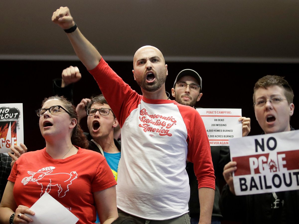 Brandon Harami, center, and others yell during a California Public Utilities Commission meeting in San Francisco, Monday, Jan. 28, 2019.