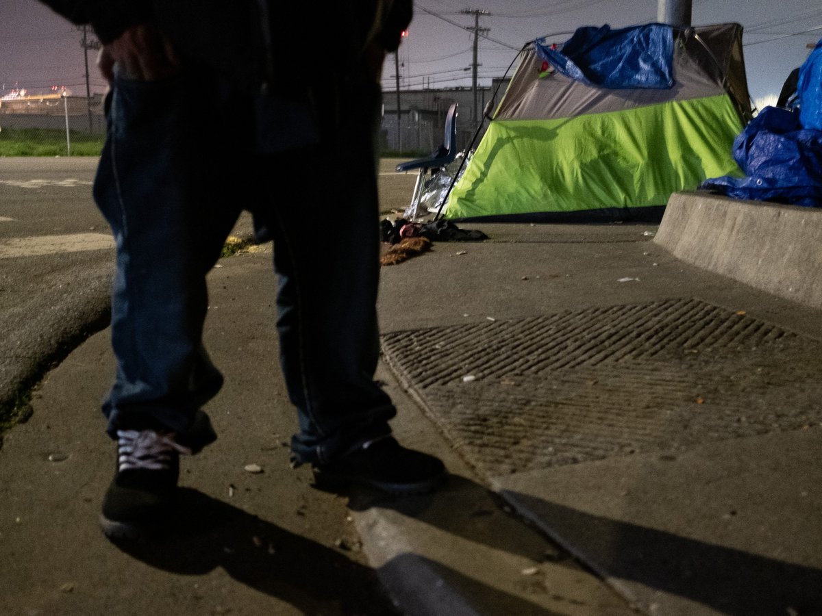 An unhoused resident stands on the sidewalk during Sacramento County's 2019 homelessness point in time count.