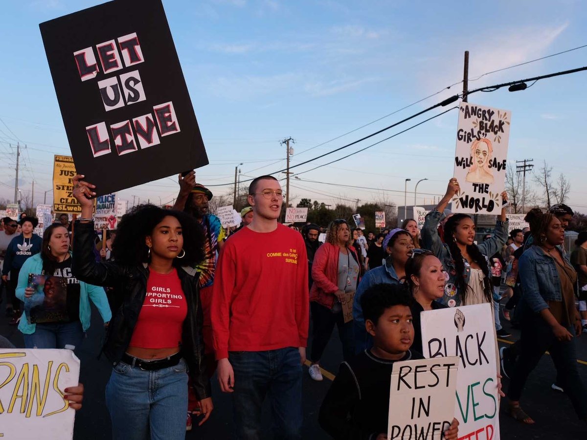 Demonstrators march down Meadowview Road on the one-year anniversary of Stephon Clark's death.