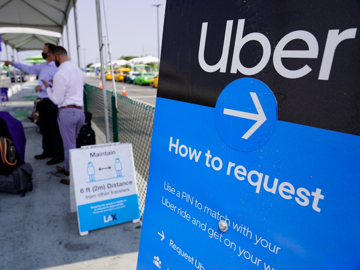 In this Aug. 20, 2020, file photo travelers request an Uber ride at Los Angeles International Airport's LAX-it pick up terminal.
