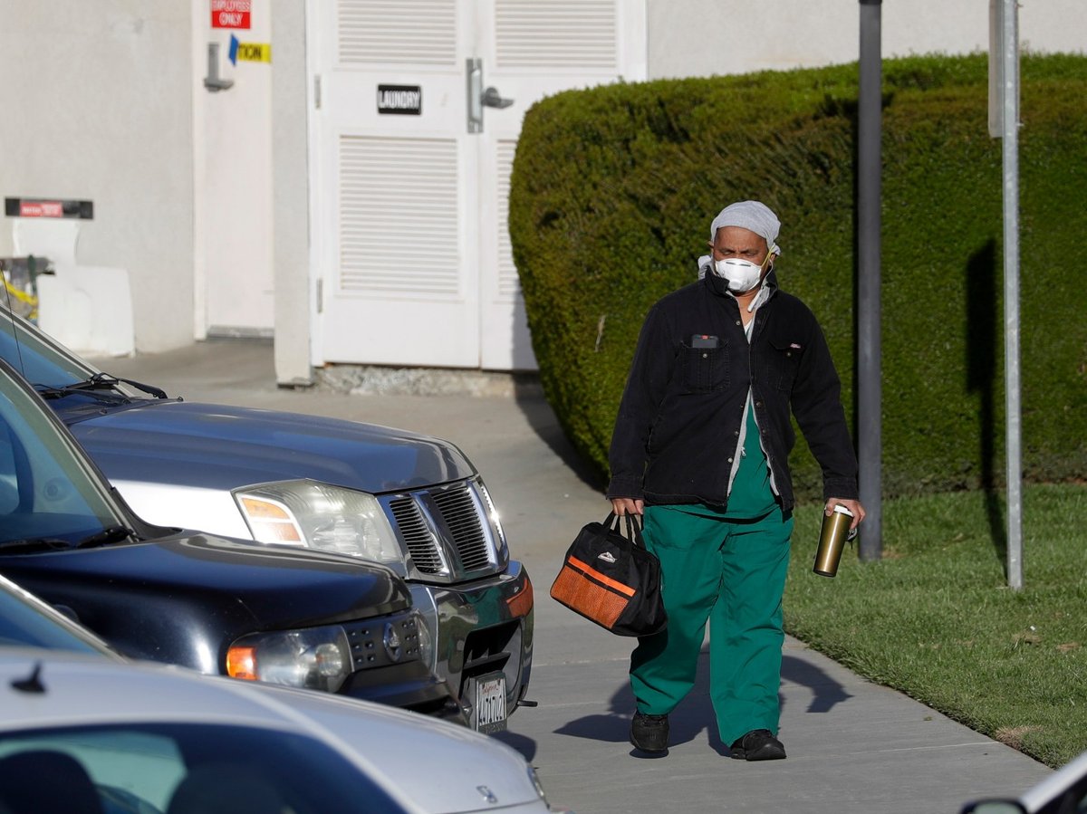 FILE - In this April 1, 2020, file photo a health care worker leaves Cedar Mountain Post Acute nursing facility in Yucaipa, Calif.
