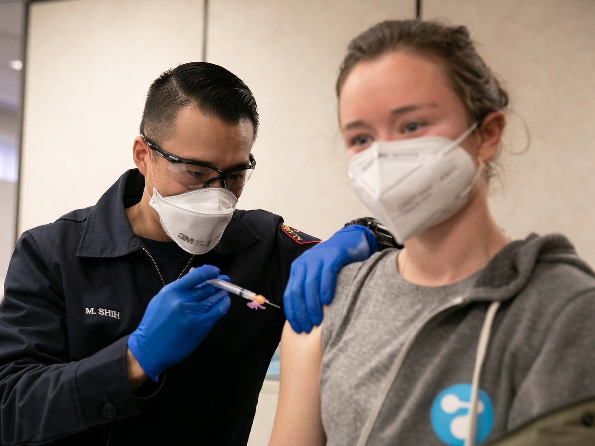 Alameda County Fire Department employee Max Shih, left, administers the second dose of the Moderna COVID-19 vaccine to Julia Jackson, a volunteer at a Berkeley needle exchange program, at St. Rose hospital in Hayward on Jan. 27, 2021.