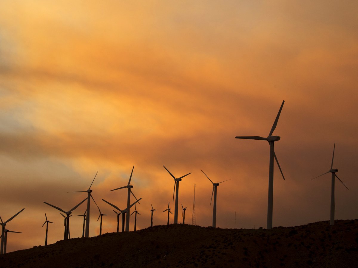 Smoke rise behind windmills from the Apple Fire during the sunset near Whitewater, Calif., Sunday, Aug. 2, 2020.