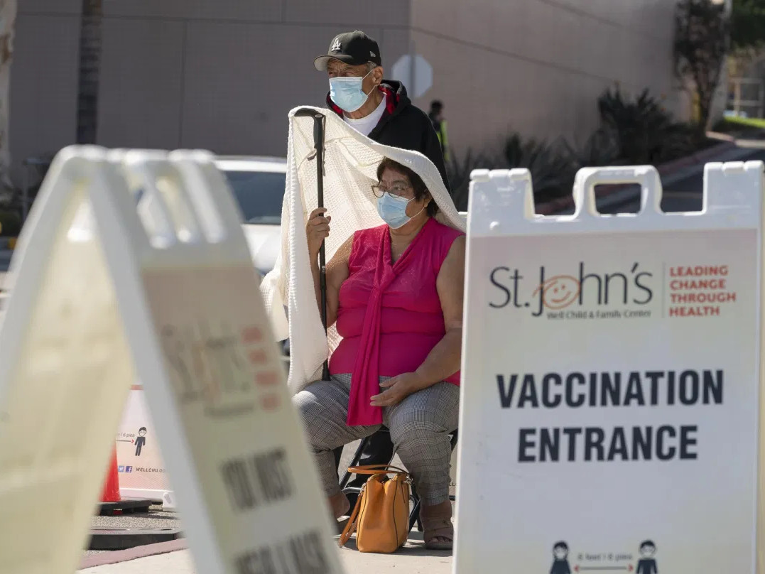 Jose Rosas and his wife, Sara, who live in the 90060 ZIP code, wait in line to be vaccinated at the St. John's Well Child and Family Center in Los Angeles on March 4, 2021. \
