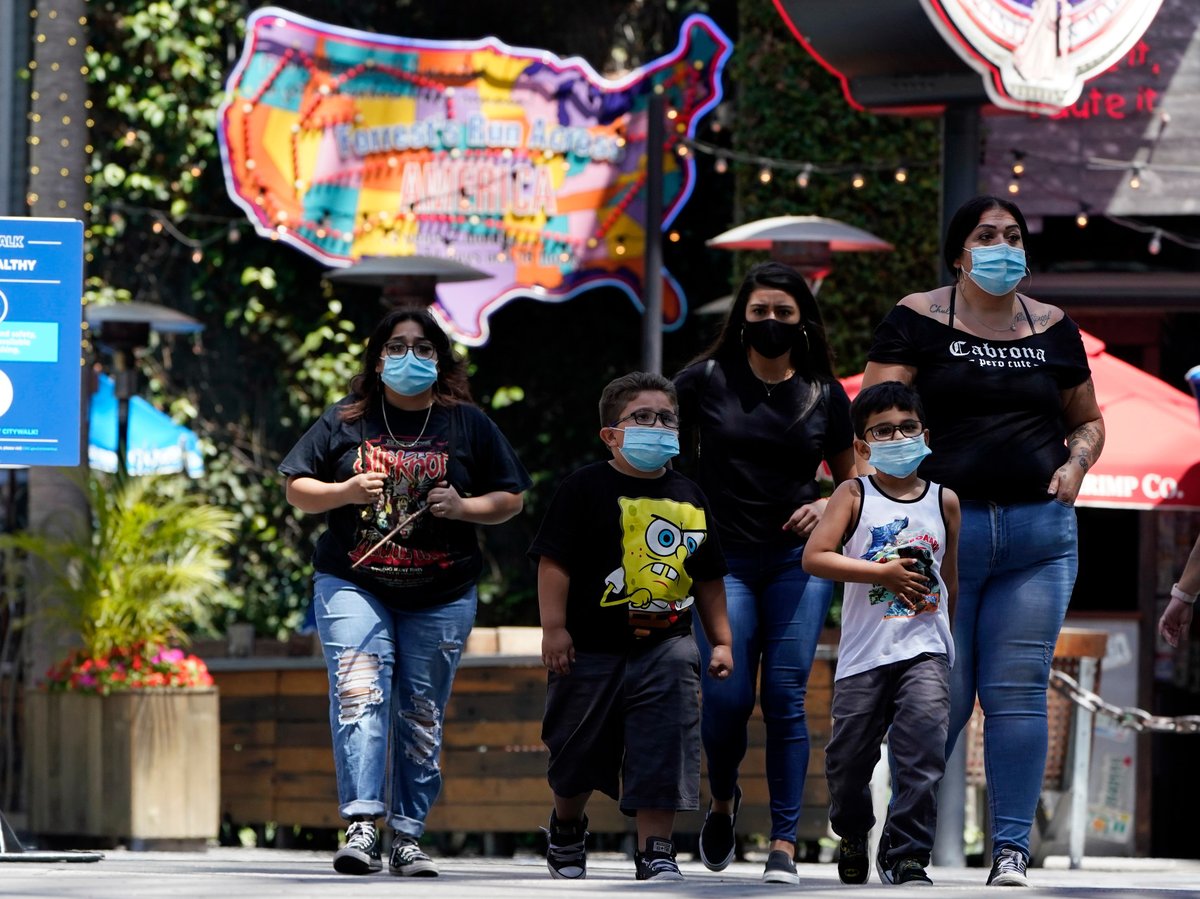 Visitors wear masks amid the COVID-19 pandemic at the Universal City Walk Friday, May 14, 2021, in Universal City, Calif.