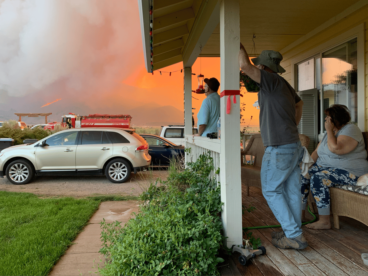 John and Karen Bohl watch the advancing Sugar Fire from their front porch. Their neighbor, middle, came by to check on them.