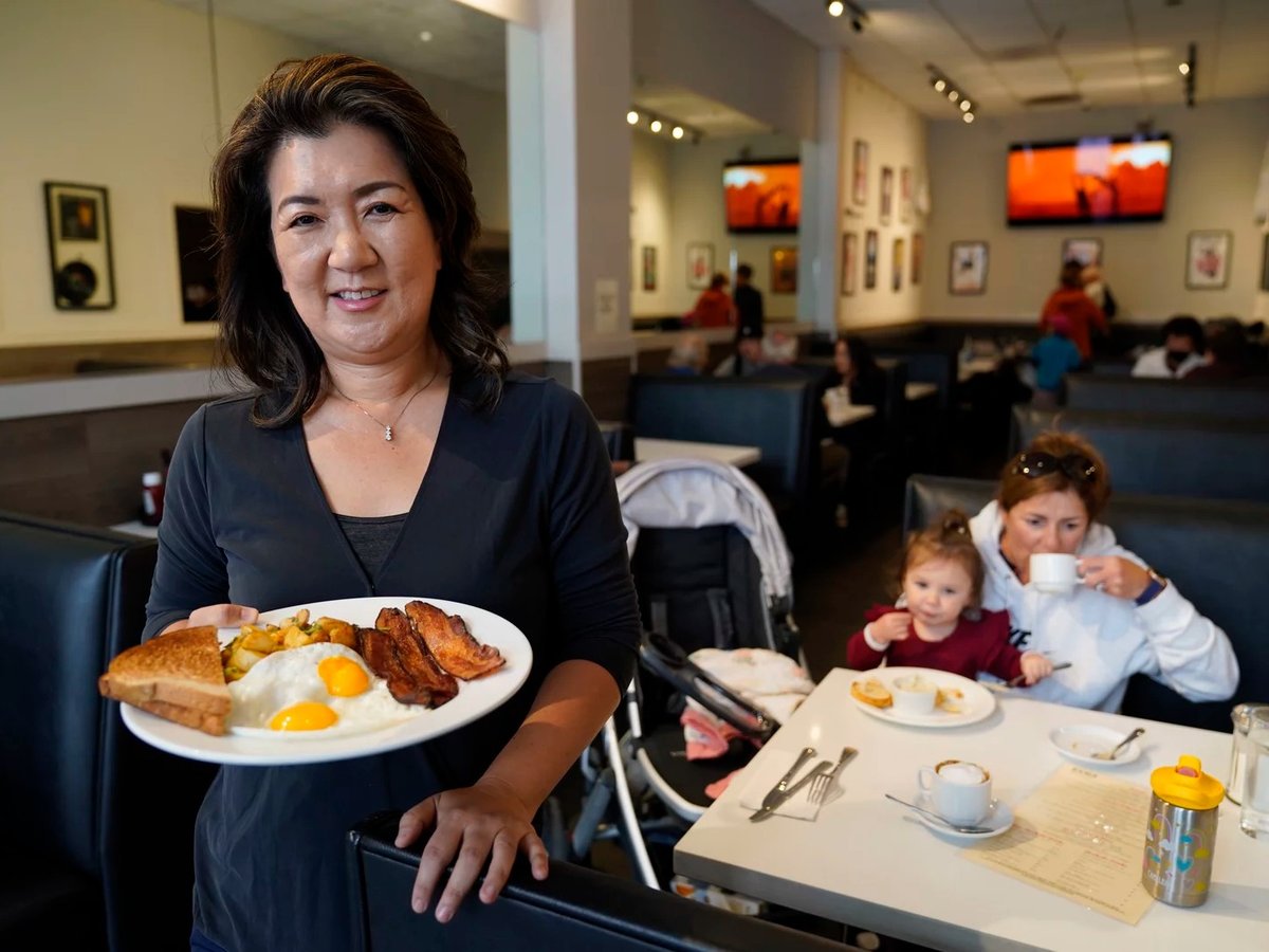 Jeannie Kim holds her popular bacon and eggs breakfast at her restaurant in San Francisco. Thanks to a reworked menu and long hours, Kim managed to keep her business alive during the pandemic.