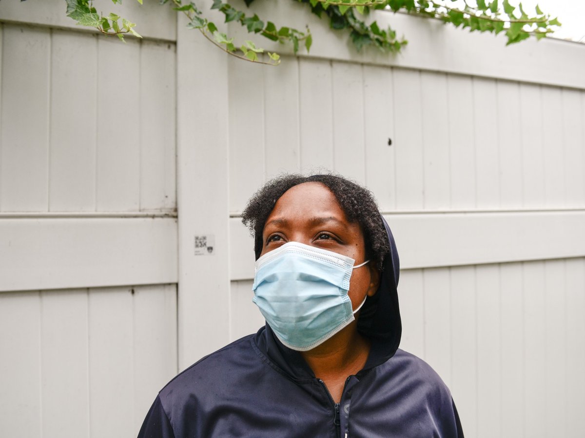 Rasheena McCord stands outside the hotel in Long Beach where McCord and her kids are living, on July 26, 2021. According to McCord, she has had to sleep on park benches after getting evicted last year.