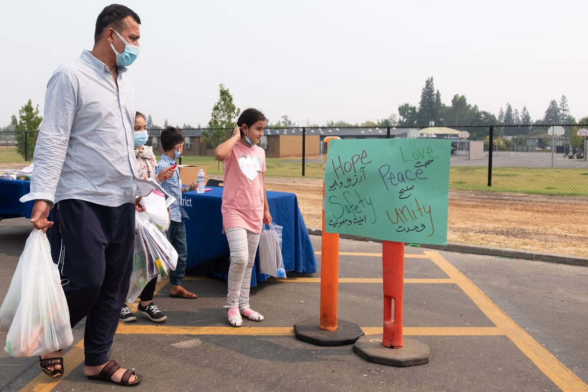 Abdul Azizi and his children attend a food distribution and resource fair at Encina High School Thursday, Aug. 19, 2021.