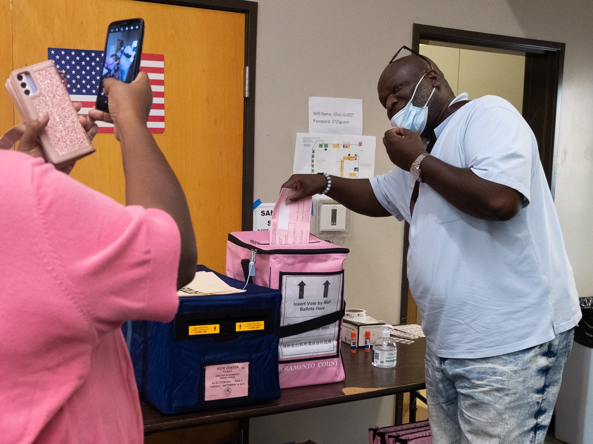 Election inspector Candice Hampton takes a photo of David McKinney, a Sacramento County voter, dropping off his recall ballot at the Greater Sacramento Urban League polling location on Tuesday, Sept. 14, 2021.