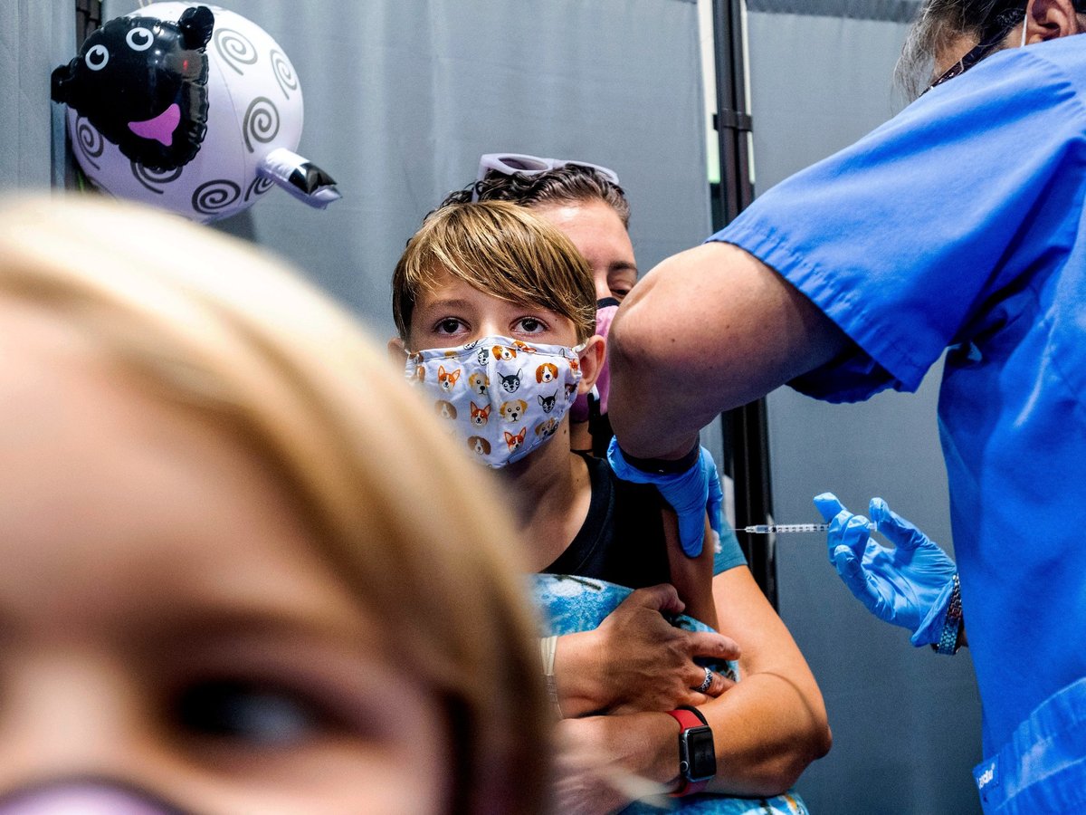 Finn Washburn, 9, receives an injection of the Pfizer-BioNTech COVID-19 vaccine in San Jose, Calif., on Wednesday, Nov. 3, 2021, as his sister, Piper Washburn, 6, waits her turn.