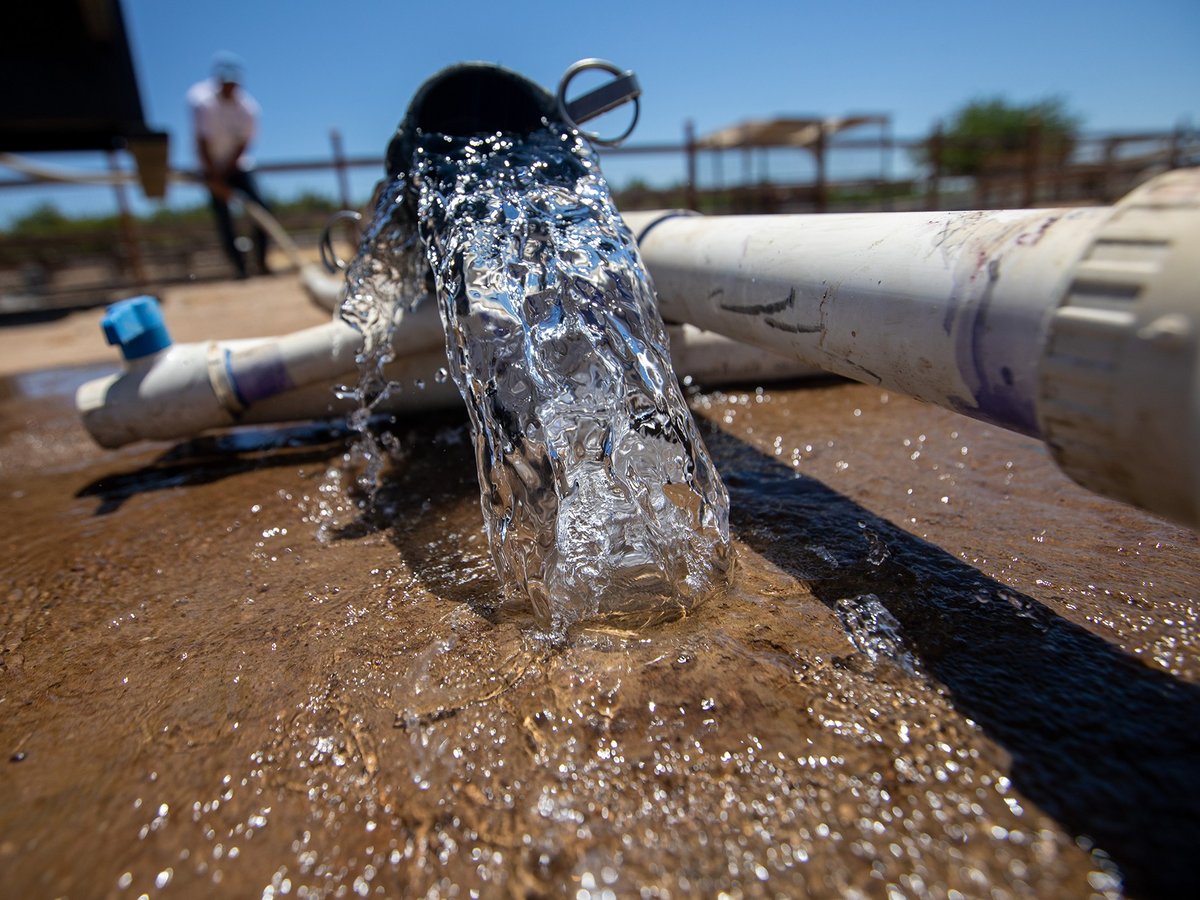 Water pours from a pipe before being connected to a water tank near Madera on June 10, 2021.