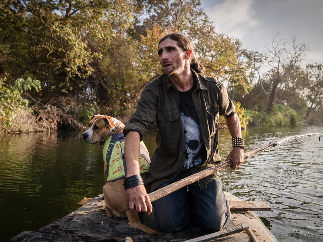 Josh Lowe made a makeshift raft out of longboards and wood to get across the San Mateo Creek to where he has been staying in San Clemente on Nov. 6, 2021.