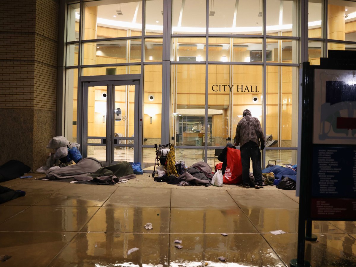People attempting to shelter outside City Hall on Dec. 13, 2021.