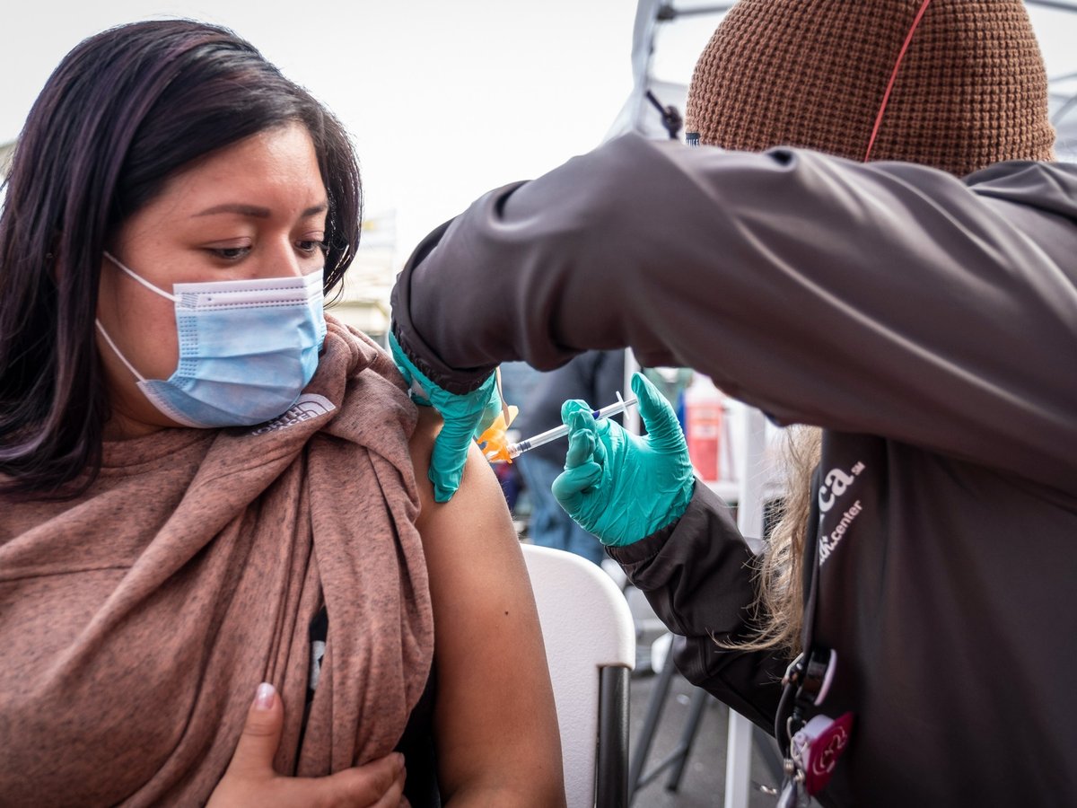 Florinda Matias Pablo receives a COVID-19 vaccination at the La Clinica de la Raza community vaccination site in Oakland on Jan. 4, 2022.