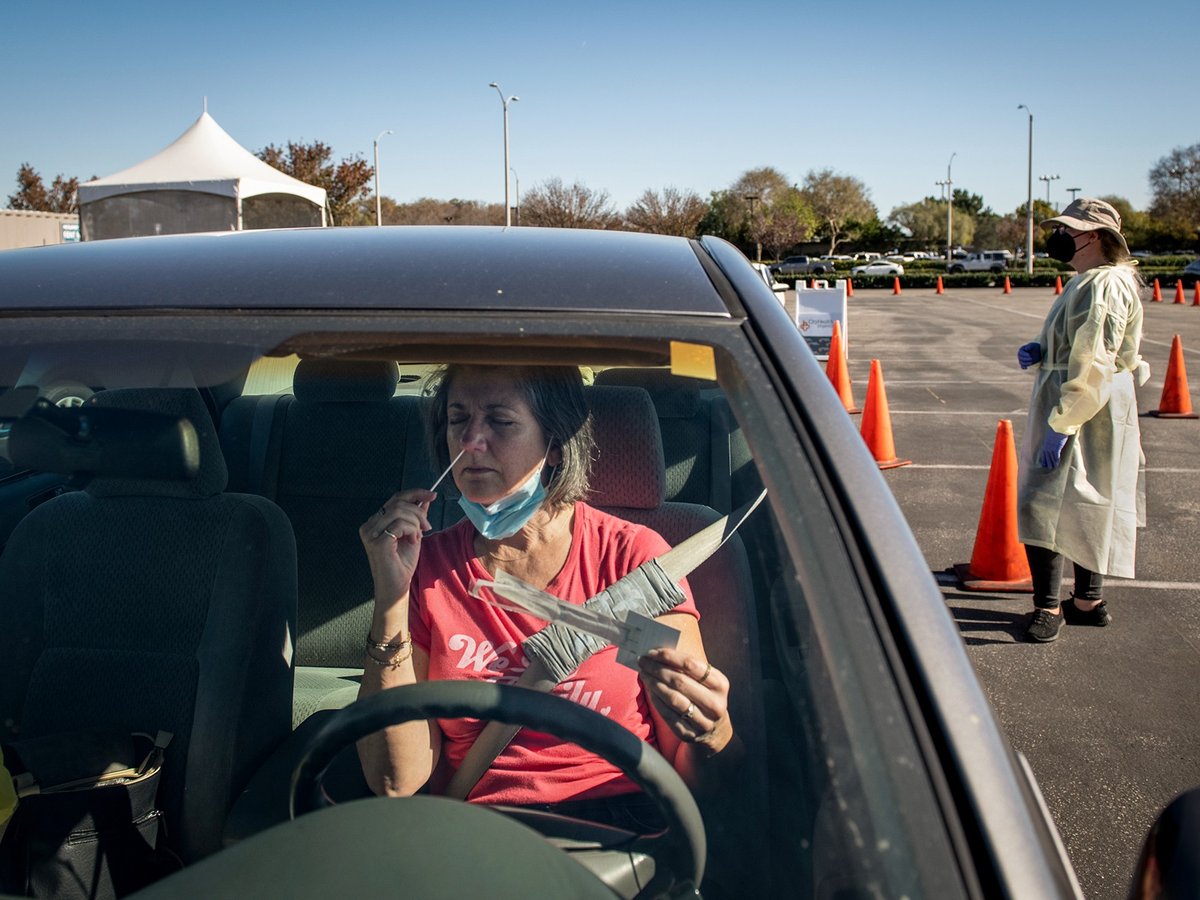 Diane Ahern swabs herself for COVID-19 at a testing site at the Long Beach Airport in Long Beach on Jan. 11, 2022. “I need to get tested every three days to be able to visit my parents at their retirement home,” Ahern said. “I’m nervous.”