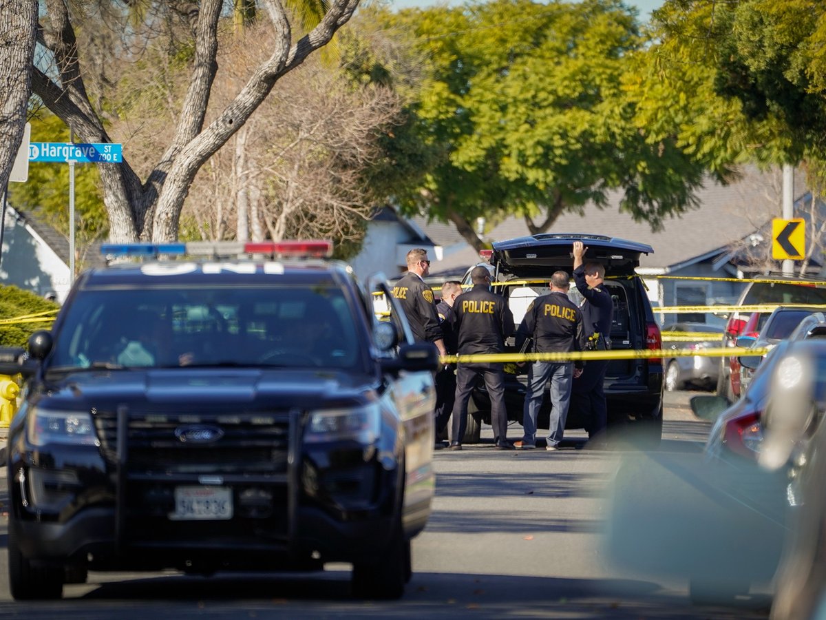 Police investigators stand at a command post near a crime scene in Inglewood on Jan. 23, 2022.