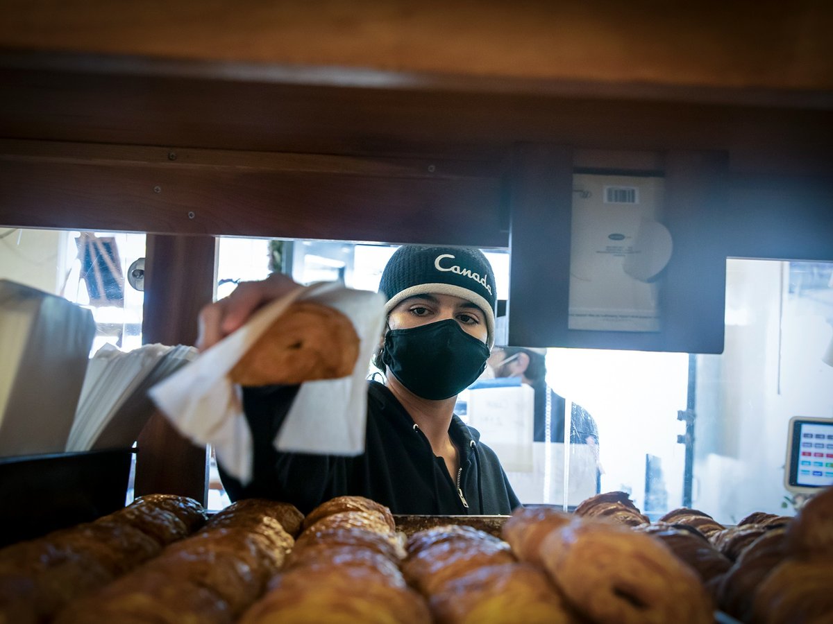 Luna Walker bags chocolate croissants for patrons at Nabolom Bakery in Berkeley on Jan. 19, 2022.