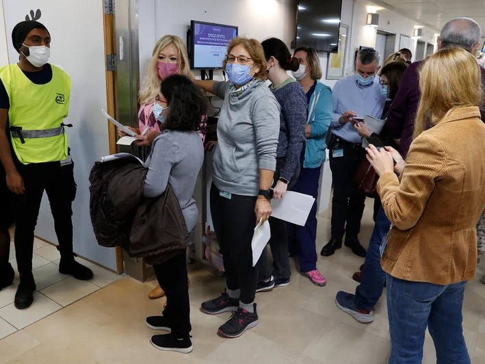 Staff volunteers queue to receive a fourth dose of the Pfizer COVID-19 vaccine at Sheba Medical Center in Israel on Dec. 27, 2021, as the hospital conducted a trial of a fourth jab of the vaccine.