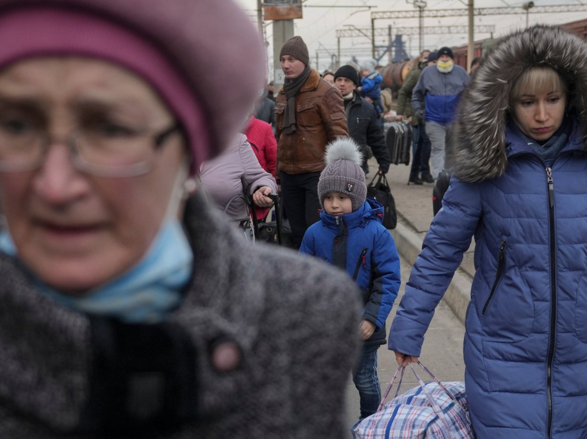 People rush on a platform to board a Kyiv bound train, on a platform in Kramatorsk, the Donetsk region, eastern Ukraine, Thursday, Feb. 24, 2022.