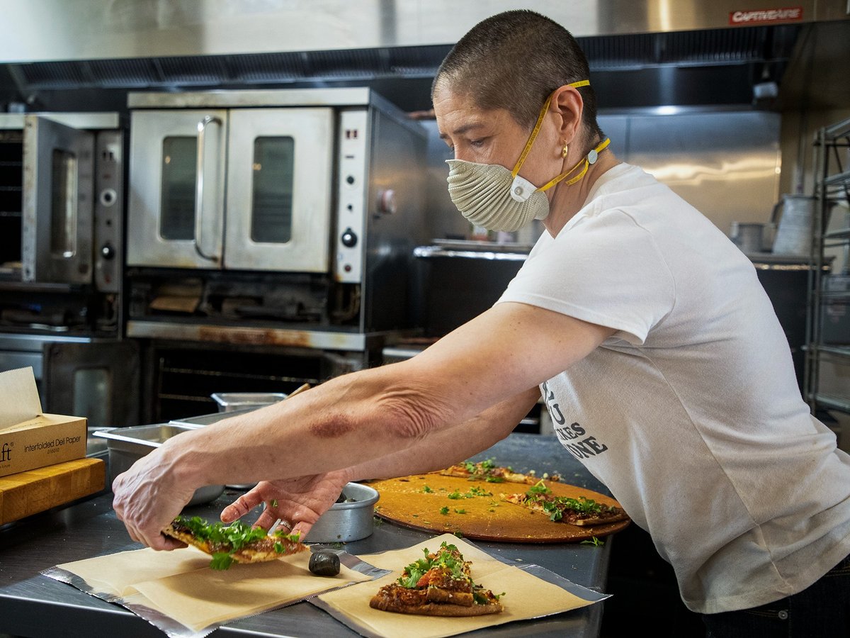 Julia Elliott prepares slices of pizza for customers at Nabolom Bakery in Berkeley on Jan. 19, 2022.