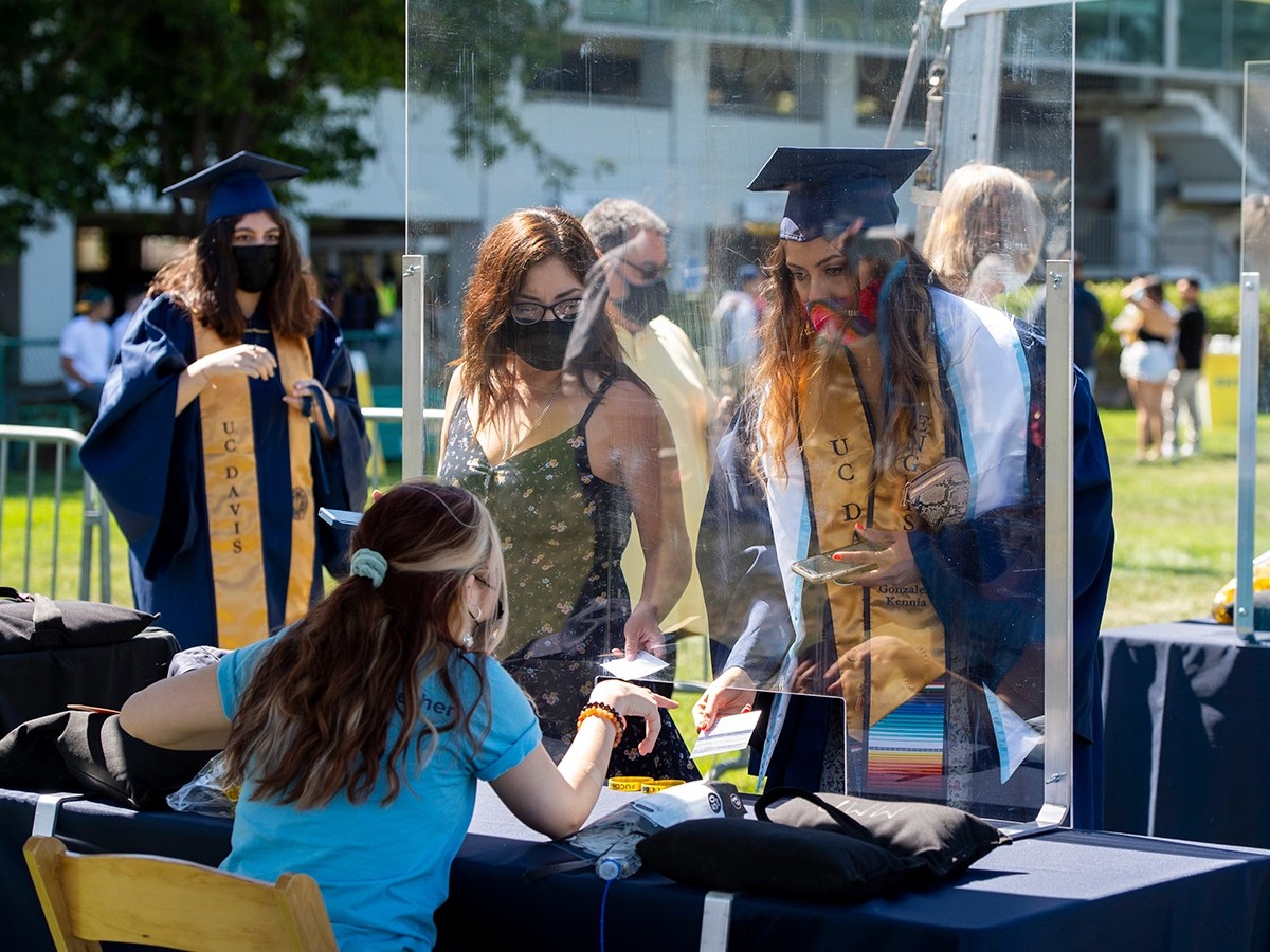 University of California-Davis students and family show either proof of vaccination or a negative covid test at a screening station before entering the University Credit Union Center for graduation ceremonies on June 11, 2021.(Lezlie Sterling / The S