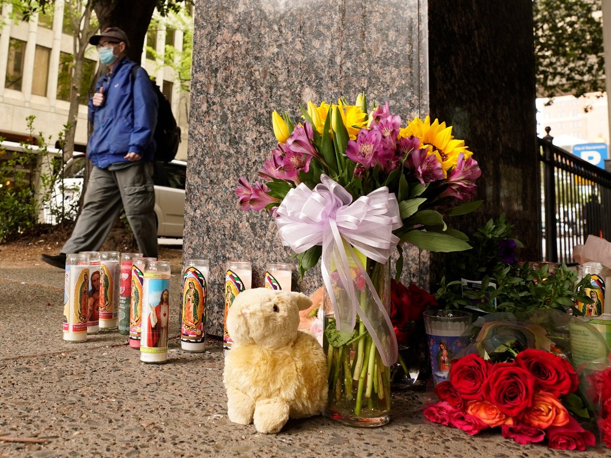 A person passes a memorial near the location of a mass shooting in Sacramento, Calif., Monday, April 4, 2022. Multiple people were killed and injured in the shooting a day earlier.
