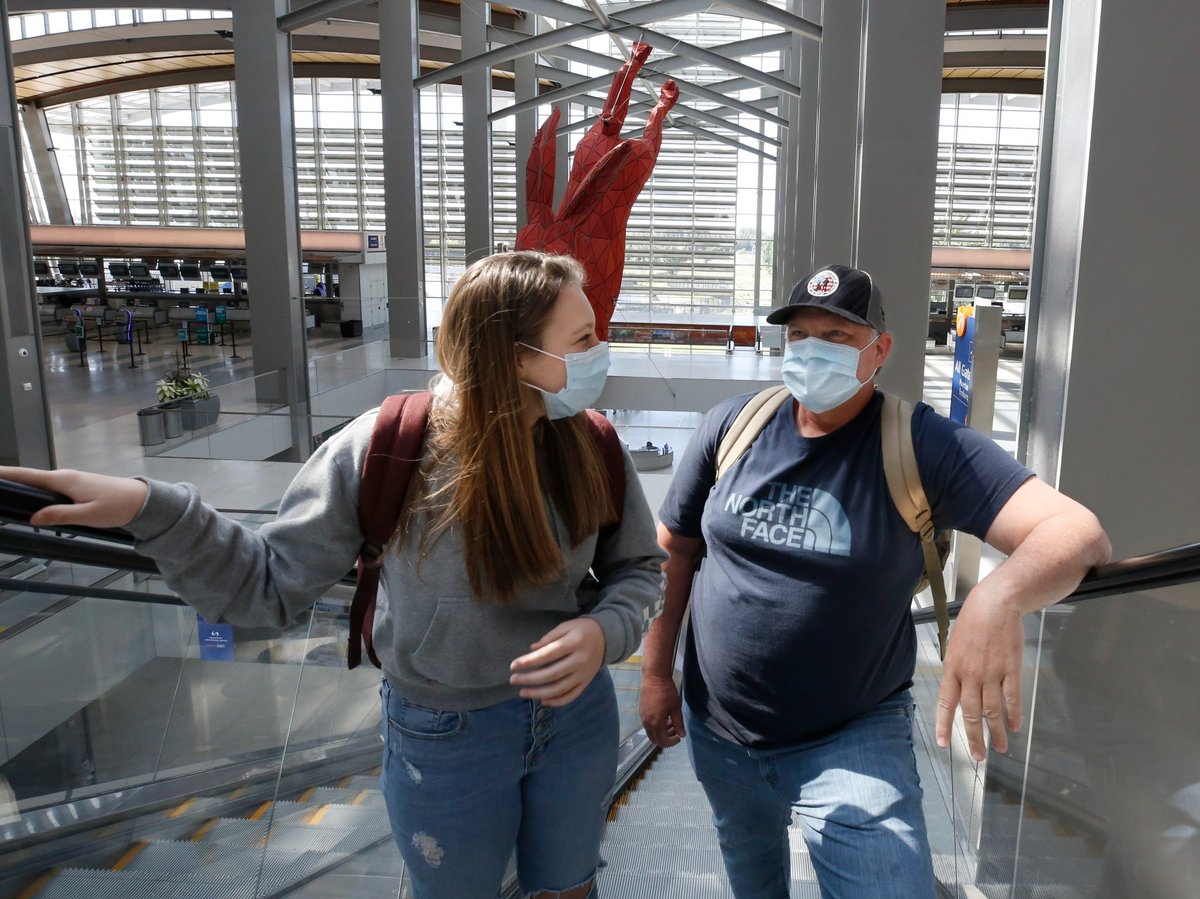 Southwest Airlines passengers Anna Bell, left, and her father, Steve, wear face masks as they go to the boarding gates at Sacramento International Airport in Sacramento, Calif., Monday, May 11, 2020.
