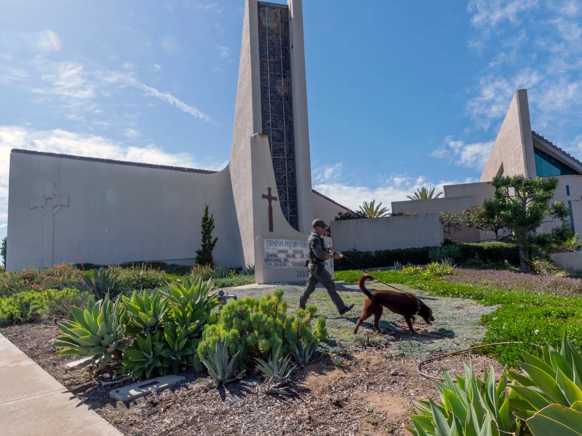 An Orange County Sheriff's Department K-9 unit checks the grounds at Geneva Presbyterian Church in Laguna Woods, Calif. on Sunday after a fatal shooting.