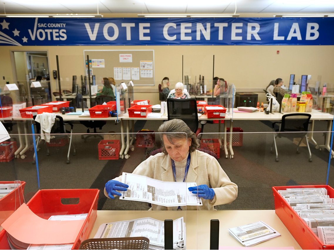 Election worker Donna Young inspects a mail-in ballot for damage at the Sacramento County Registrar of Voters in Sacramento, Calif., Friday, June 3, 2022.