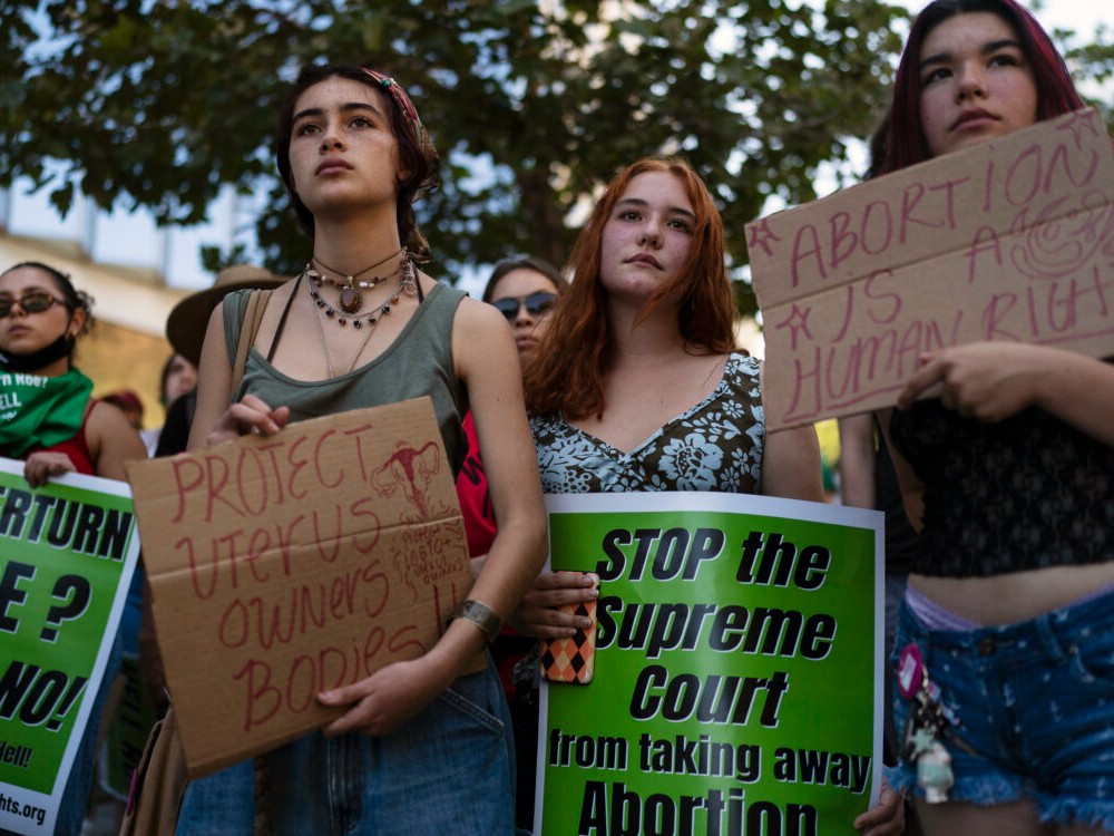 A group of young women listen to a speech during a protest outside a federal courthouse in Los Angeles on June 24, 2022.