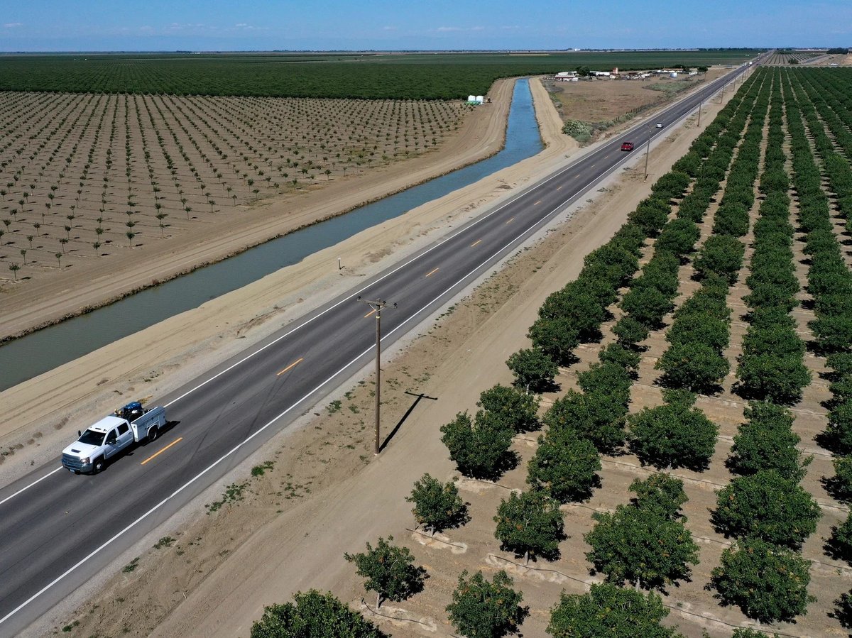 A vehicle drives by an almond orchard in Firebaugh, Calif., last year.