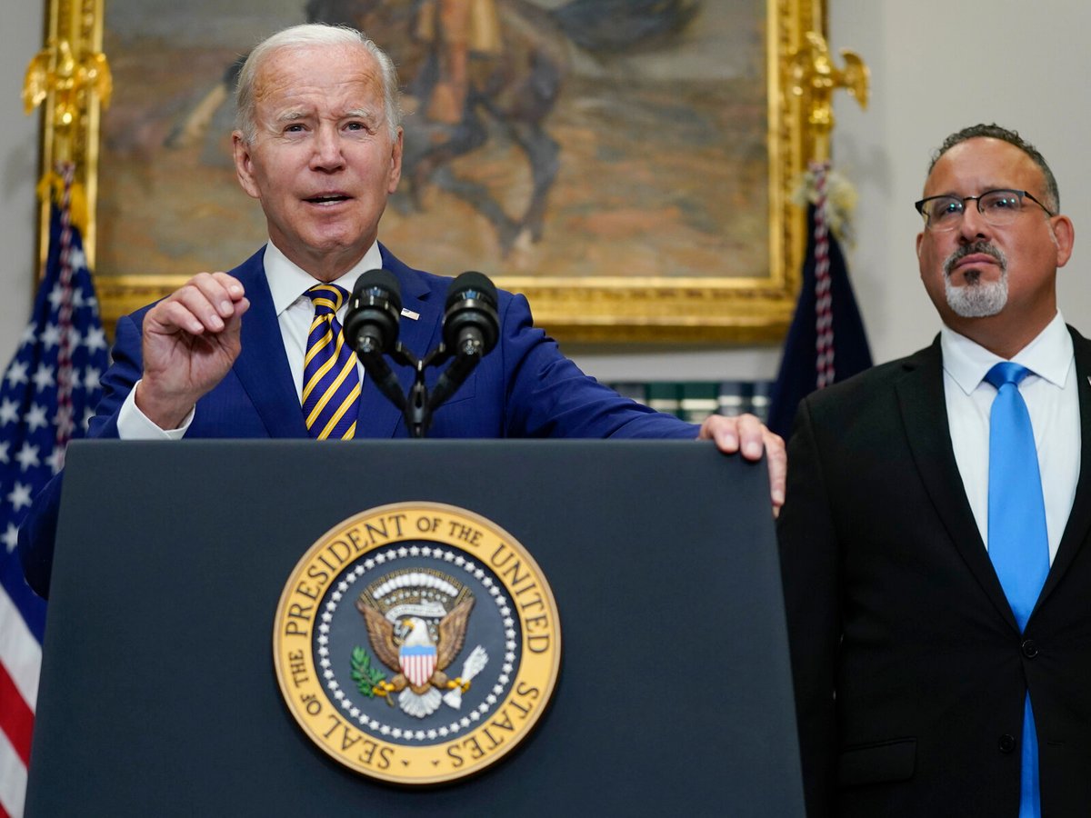 President Joe Biden speaks about student loan debt forgiveness at the White House on Wednesday, with U.S. Education Secretary Miguel Cardona by his side.