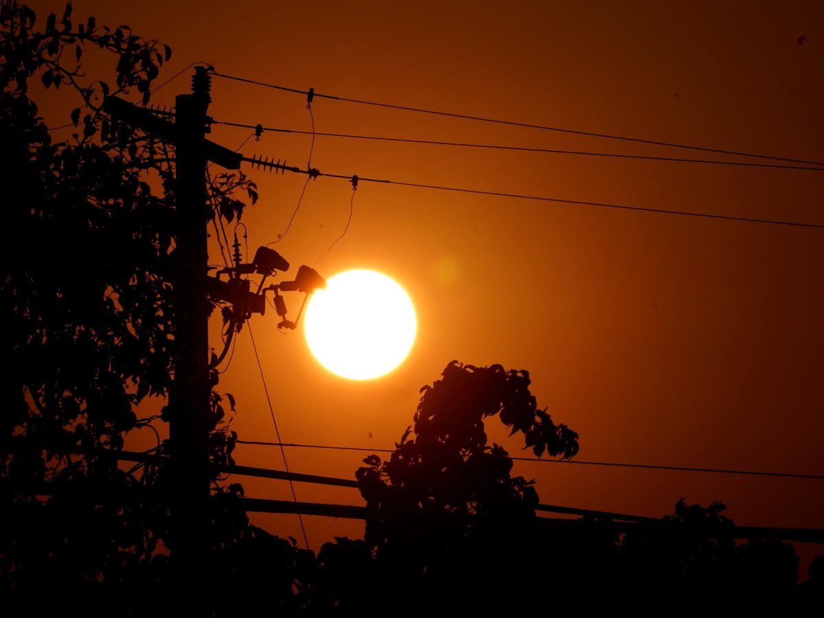 A red sky sunrise is seen between power lines in Sacramento, Calif., Thursday, Sept. 8, 2022. Temperatures in the Sacramento area are expected to go over the 100 degree mark and that could put a strain on the power supply.