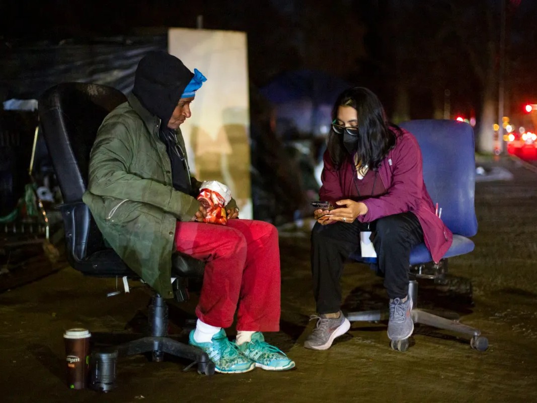 Victoria Gonzalez-Gerlach interviews an unhoused person during Sacramento's Point-in-time count of the homeless population in the city on Feb. 24, 2022.