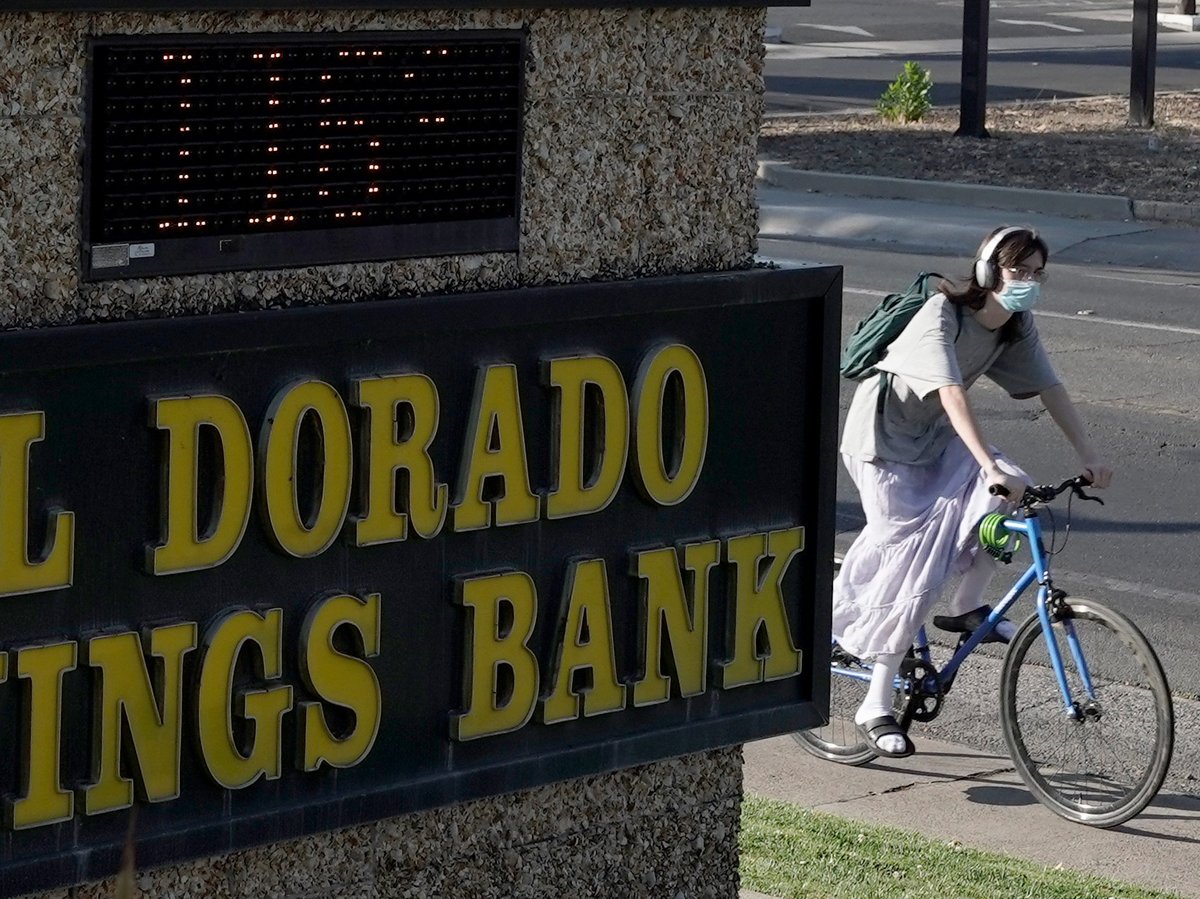 A bicyclist passes a bank sign displaying a temperature of 116 degree in Sacramento, Calif., Monday, Sept. 5, 2022.
