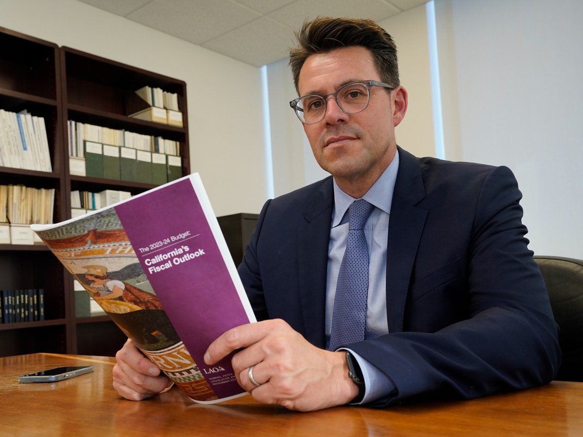 Legislative Analyst Gabriel Petek displays a copy of his office's analysis of the state's fiscal outlook for 2023-24 that was released on Wednesday, Nov. 16, 2022, in Sacramento, Calif.
