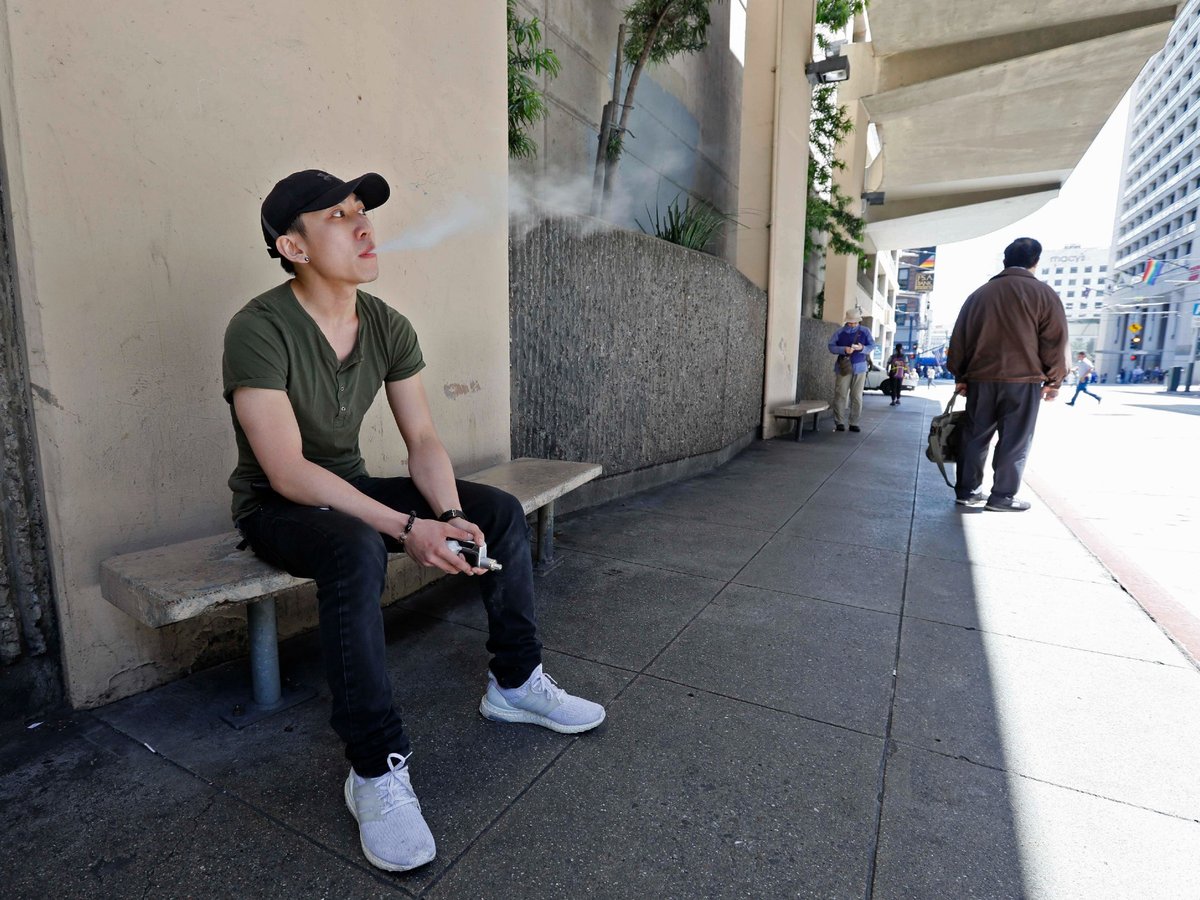 In this June 17, 2019, file photo, Jacky Chan takes a vaping break from his job at a smoke shop in San Francisco.