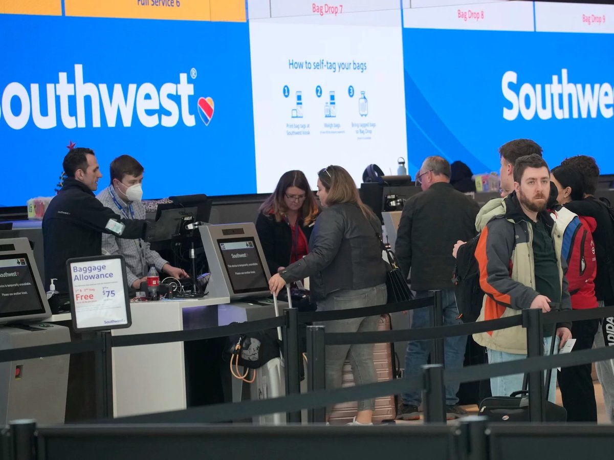 Travelers are shown lining up at the check-in counters for Southwest Airlines in Denver International Airport, Friday, Dec. 30, 2022, in Denver.