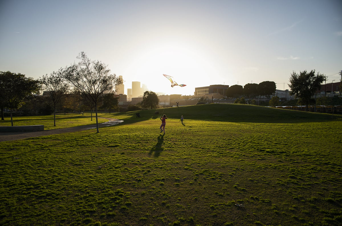 Young children play and fly their kites as the sun begins to set at the Los Angeles State Historic Park in Los Angeles on Jan. 6, 2023. Pablo Unzueta for CalMatters
