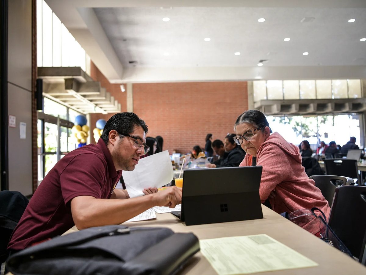 Isaias Hernandez, executive director of the Eastmont Community Center, helps a person with their taxes during a free tax preparation event at the Nakoak Community Center in Gardena on April 1, 2023.