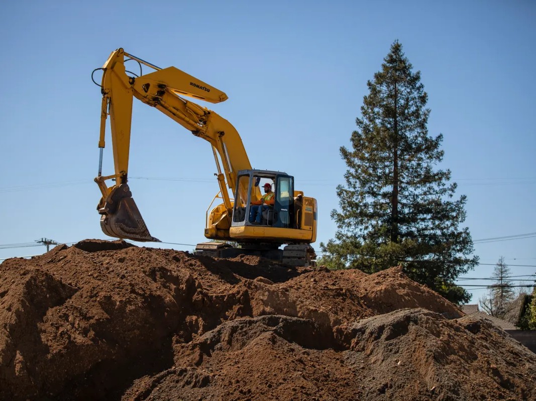 An excavator operates at the Quito Village Development Project in Saratoga on Apr. 13, 2023.