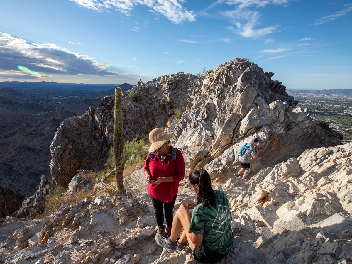 Early morning hikers rest before walking down Piestewa Peak, a city park in Phoenix, Ariz. El Niño makes a record-breaking average annual temperature for Earth more likely.