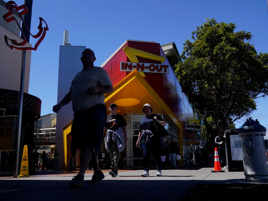 Pedestrians walk outside of an In-N-Out Burger restaurant in San Francisco, Thursday, Aug. 25, 2022.