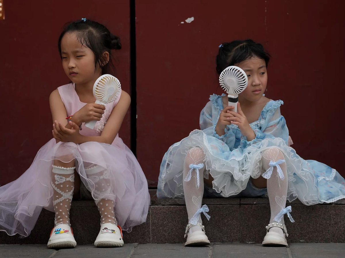 Children cool themselves with electric fans in Beijing on June 25, 2023. The National Oceanic and Atmospheric Administration says this was the hottest June on record globally.