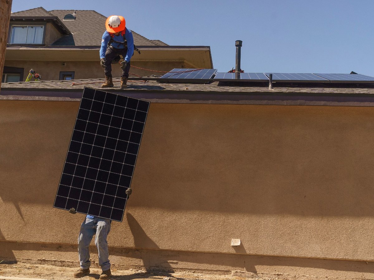 Technicians from SunPower Corp., brave the extreme heat as they install solar panels on a residence's roof in Pasadena, Calif., Wednesday, July 19, 2023.