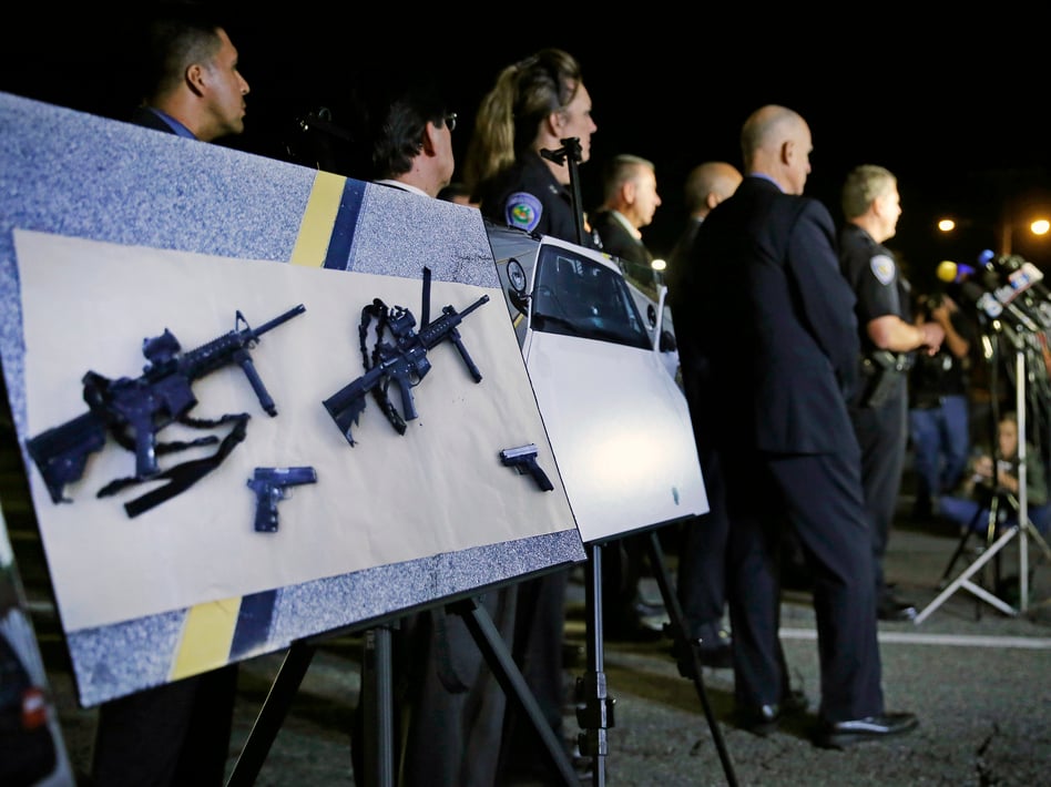 Police crime photos of assault rifles and handguns are displayed during a news conference near the site of a mass shooting in San Bernardino, Calif., on Dec. 3, 2015.