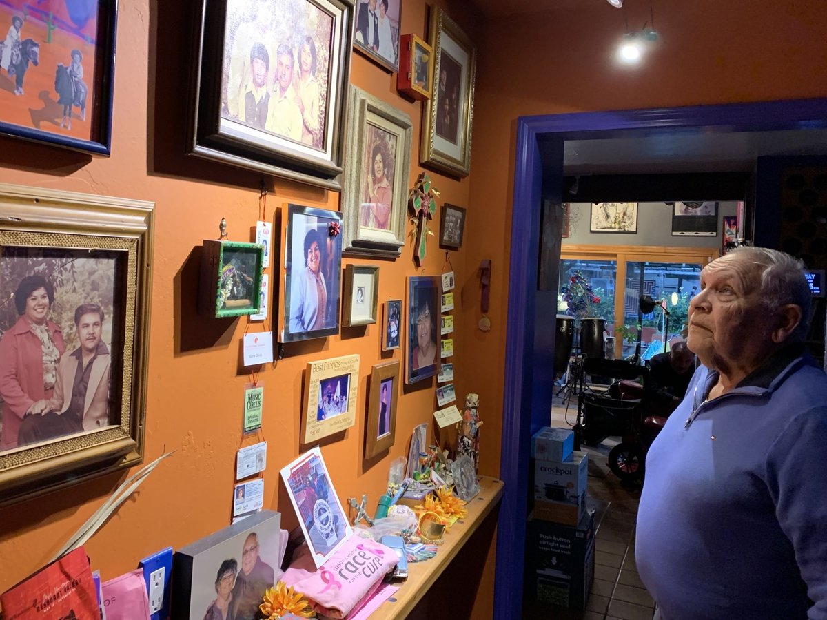 Carlos Olivas II, known as "Charlie," looks up at photos of his late wife and family inside his East Sacramento home on Nov. 27, 2023.