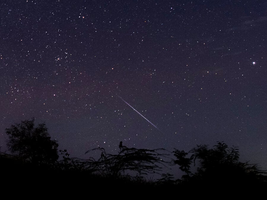 This photo taken late December 14, 2018 with a long time exposure shows a meteor streaking through the night sky over Myanmar during the Geminid meteor shower seen from Wundwin township near Mandalay city.